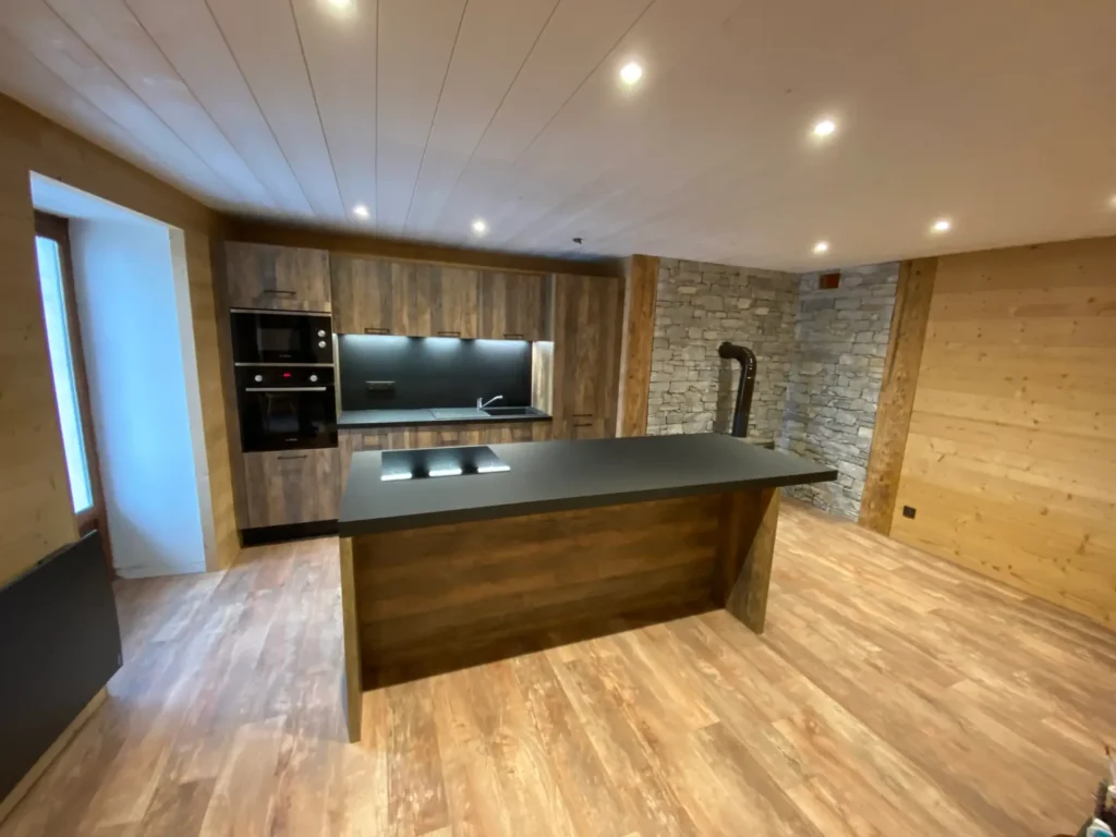 Cuisine avec îlot central et mur en pierre
