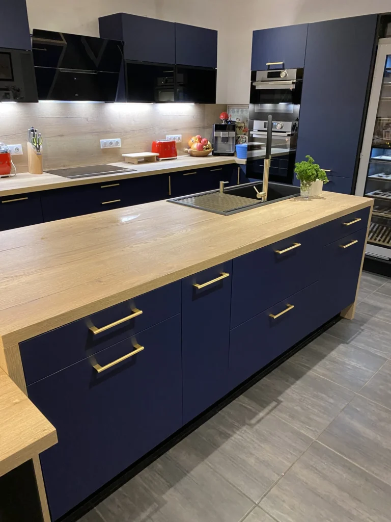 Cuisine bleu nuit avec grand îlot central et plan bois